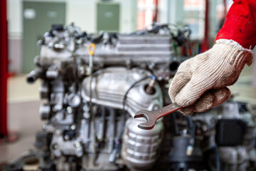 A car mechanic repairs an engine in a car service.