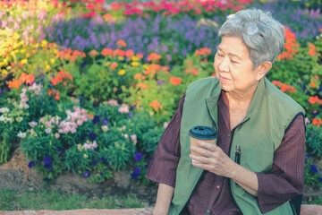 asian old elderly elder woman drinking coffee tea in garden. senior leisure lifestyle