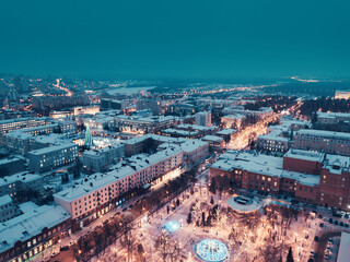 Aerial drone view of an evening city in winter with streets and intersections lit up and ready for...