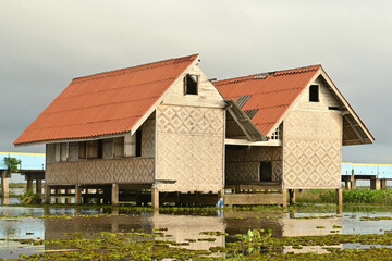 The old traditional red roof houses nearly the lagoon in south east asia culture.