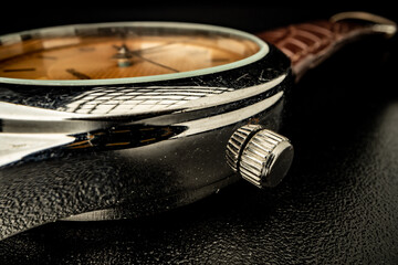 Old metal watch dial in dark macro photo