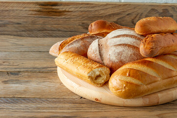 Types of homemade bread on the rustic wooden table. Homemade baked pastry.
