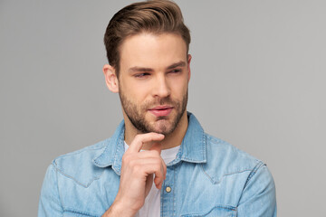 Portrait of young handsome caucasian man in jeans shirt over light background