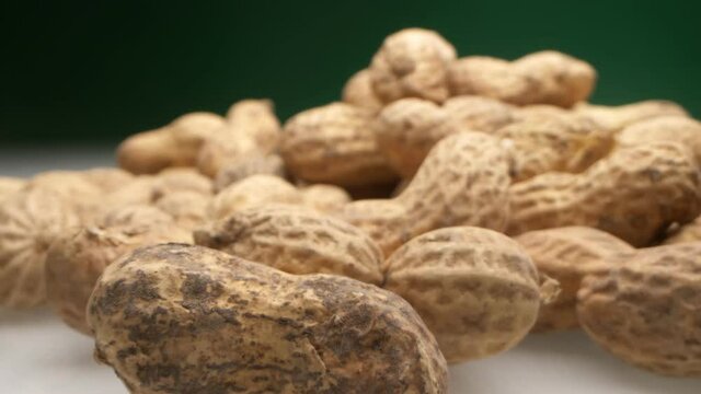 extremely close-up, detailed. peanuts in shells on a dark background.