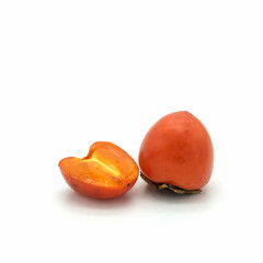 Ripe bright persimmon isolated on white background. One whole fruit and half. Bottom right corner.