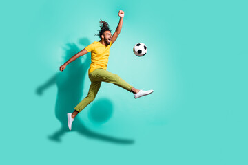 Obraz na płótnie Canvas Full size profile side photo of young happy positive excited african man play football in air isolated on turquoise color background