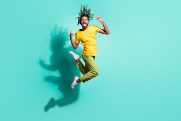 Fototapeta na wymiar Full size photo of young happy smiling crazy excited afro man jumping show rock n roll sign isolated on turquoise color background