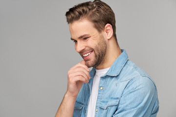 Portrait of young handsome caucasian man in jeans shirt over light background