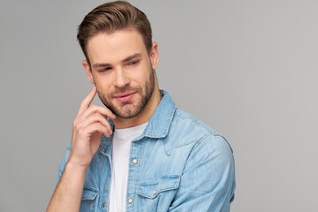 Fototapeta premium Portrait of young handsome caucasian man in jeans shirt over light background
