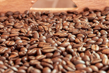 Fototapeta premium A wooden box full of roasted coffee beans.