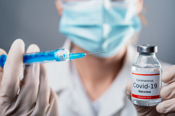 Doctor holding a syringe with a single bottle vial of Covid-19 vaccine for children or adults....