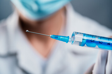 Doctor holding a syringe with a single bottle vial of Covid-19 vaccine for children or adults....