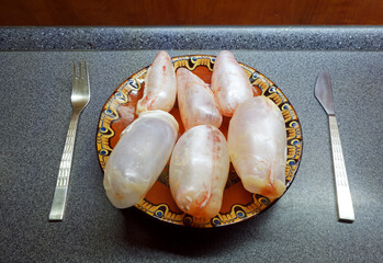 Carp bladders on a kitchen counter with cutlery