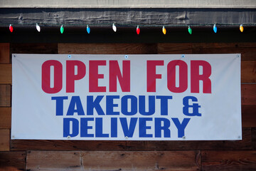 Restaurant banner sign OPEN FOR TAKEOUT AND DELIVERY during the coronavirus Covid-19 pandemic