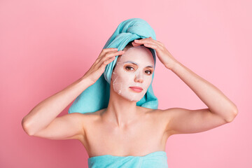 Portrait of young lovely pretty happy positive girl applying moisturizing face mask wear teal turban isolated on pink color background