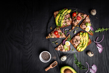 Tuna bruschetta sandwiches collection. Delicious breakfast or snack. Toasts with tuna delicious healthy food on a dark background, Top view