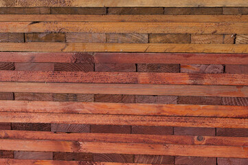 Stained wood background with grain in assorted colours of red and brown