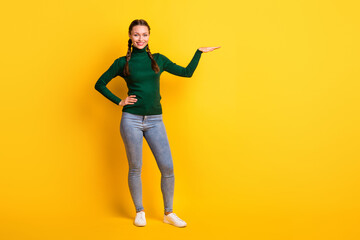 Fototapeta na wymiar Photo portrait full body view of girl showing height with hand isolated on vivid yellow colored background