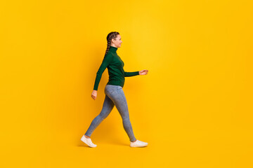Fototapeta na wymiar Full length body size photo of female student with braids in jeans turtleneck walking forward isolated on vibrant yellow color background