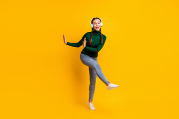 Fototapeta na wymiar Full length body size view of lovely cheerful girl listening music having fun dancing isolated on bright yellow color background