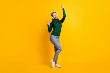 Fototapeta na wymiar Full length body size photo female student in earphones singing song listening music isolated on vivid yellow color background