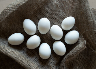 White chicken eggs on a coarse linen napkin