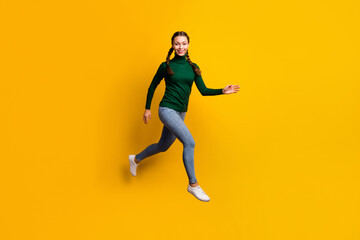 Fototapeta na wymiar Full length body size photo smiling woman jumping high in casual clothes isolated on bright yellow color background