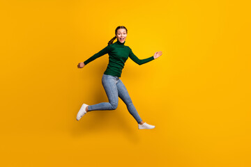 Fototapeta na wymiar Full length body size view of lovely slim cheerful girl jumping running having fun isolated on bright yellow color background