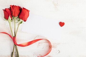 three roses and white paper for message