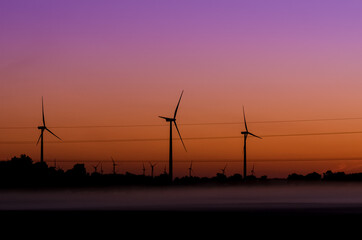 Fototapeta na wymiar WIND FARM - Renewable energy sources at sunrise