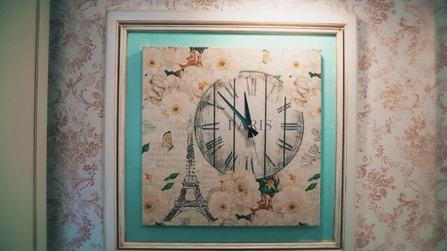 french clock with the eiffel tower and the inscription paris hang on the wall