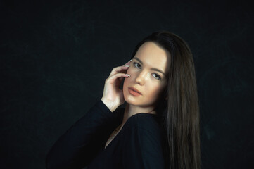 Portrait of a young beautiful woman in the studio on a dark background