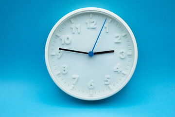 Closeup of modern analog clock on blue background