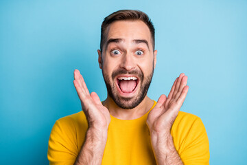 Photo of young crazy excited happy smiling cheerful man in yellow t-shirt see big sale isolated on blue color background