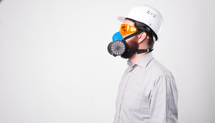 Profile photo of man in shirt wearing white helmet and breathing trough the respirator.