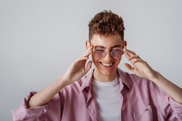 Young fashionable happy smiling guy wearing trendy lilac sunglasses, color shirt, white t-shirt....