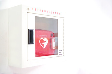 Automated External Defibrillator (AED) in white box on the wall Is an emergency pacemaker device for people with cardiac arrest. Heart defibrillator on white background..