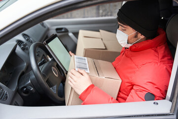 Courier in protective mask looking at the box