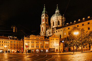Obraz premium Night view of the illuminated St Nicolas church, Malostranske namesti,Prague,Czech republic.Baroque church in the Lesser Town of Prague.Night city scene.Famous tourist destination.Czech architecture.