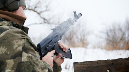 Effective reloading of a Kalashnikov assault rifle in winter in camouflage