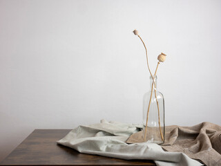 vintage interior design, dried poppy stems inside a bottle on the table, minimal style home...