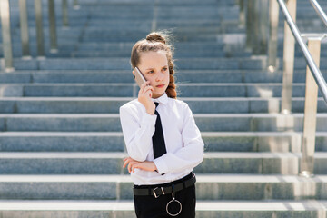 Little school girl having phone talk with friend. modern life communication. Living in digital age.