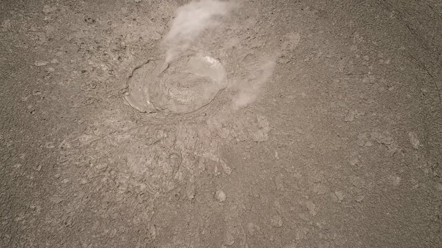 Mud volcano with bursting bubble bledug kuwu, slow motion. aerial view volcanic plateau with geothermal activity and geysers, Indonesia java. aerial view volcanic landscape