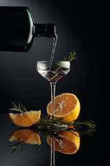 Gin with lemon and rosemary on a black reflective background.