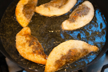 Gyoza dumplings with mushroom filling frying in hot pan. Golden crunchy dumplings cooking in oil.