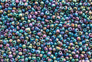 Background texture of multicolored iridescent beads closeup. Seamless beads texture. Hobbies, handmade jewelry, craft. Abstract background