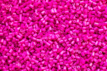 Background texture of hot pink beads closeup. Seamless beads texture. Hobbies, handmade jewelry, craft. Abstract background