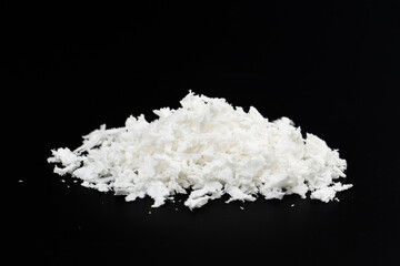 a pile of poured white artificial synthetic snow on a black background