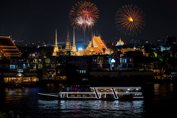 Top view of Chao Phraya River Cruise Boat with Wat Pho reclining buddha and Golden Mount in New year firework festival performance.