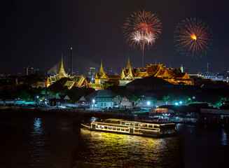 Top view of Chao Phraya River Cruise Boat with The Grand Palace and The Emerald Buddha Temple, Chakri Maha Prasat Throne Hall in New year firework festival performance.